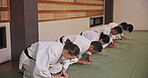 Dojo, people and respect with bow for karate, martial arts practice or greeting with honor in class. Group, students and etiquette with kneeling for learning combat, self defense or training in Japan