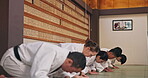 Dojo, people and respect with bow for martial arts, karate practice or greeting with honor in class. Group, students and etiquette with kneeling for learning combat, self defense or training in Japan