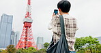 City, man and phone screen with photography for picture, vacation and travel memory with capture. Japanese, person and tourist with mobile for digital camera, social media and journey by Tokyo tower