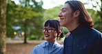 Japanese couple, happy and walking outdoor, talking and smile together with partner on vacation date. Asian man, woman and relationship at park for travel, support and romantic connection for love