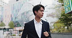 Rain, city and Japanese man with umbrella and professional on morning commute in winter. View, outdoor and cold weather on urban street with water drops, travel and Tokyo trip in storm with walk