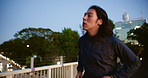 City, night and running with man on bridge for cardio exercise, fitness or training routine. Health, wellness and workout with Japanese athlete outdoor for commitment or dedication to sports