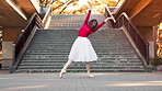 Woman, ballerina and dancing with moving in city by stairs with performance, balance and rhythm in street. Person, dancer and tutu for art with elegance, concert and spin on urban sidewalk in Japan