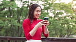Woman, phone and laugh with texting in park with reading, excited or happy for funny meme on mobile app. Person, smartphone and smile in spring with comic post, video or chat on social media in Japan