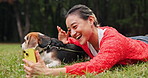 Woman, dog and video call with smile at park, wave and love with phone, excited and relax on lawn. Person, animal and pet beagle puppy with care, loyalty and happy with mobile app on grass in Japan