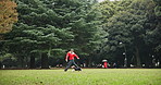 Woman, running and playing with dog on grass field in nature for fun bonding, love or animal care. Japanese, female person or pet owner enjoying game with canine on lawn at forest or outdoor park