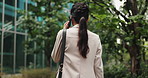 Phone call, walking and woman in business park with discussion, contact and morning commute from back. City, office building and Japanese businesswoman with smartphone, communication and urban travel