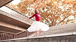 Ballet, dancer and Asian woman spin in city on stairs for street performance, dancing and practice in town. Creative, entertainment and ballerina in Japan for movement, balance and artistic talent