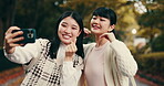 Japanese women, friends and selfie for happiness, outdoor and playful with peace sign. Female people, bonding together, and smile as post for memory, fun or social media app in park, garden or nature