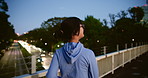 Woman, back and night with bridge for running exercise, fitness or cardio workout in city. Active, female person or runner enjoying late evening workout on path or passage in an urban town of Japan