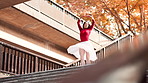 Woman, ballet and dancer with spin on stairs in city with training, balance and rhythm in street. Person, dancing and steps for art with moving, concert and low angle on urban sidewalk in Japan