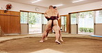 Sumo wrestling, men and fighting in ring, competition and practice with professional. Japanese, people or winner in studio, match or fitness with strength, wellness or workout with sports or training