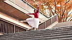 Ballet, dancing and Asian woman in city on stairs for performance, flexibility and practice in town. Creative dancer, entertainment and ballerina in Japan for movement, balance and artistic talent