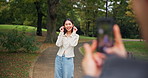 Happy, asian woman and expression with phone camera at park for photography, picture or memory. Japanese, female person or tourist with smile for travel moment, capture or post on path in forest