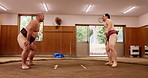 Sumo, japan wrestler or training with stretching in ring for match fitness, traditional exercise or leg practice. Warm up, man or shiko instructor with squats for flexibility workout or getting ready