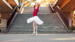 Woman, ballerina and dancing with spin in city by stairs with moving, balance and rhythm in street. Person, dancer and tutu for art with elegance, concert and performance on urban sidewalk in Japan