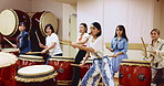 Japanese, women and music teacher with drum or instrument for taiko tradition, culture or practice. Asian, female people or drummers with sound, tool or wooden equipment for percussion class in Japan