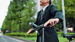 Electric bike, walking and hands of businessman in city for travel to work in morning with sustainable transport. Professional, bicycle and mature lawyer commue in town for corporate career in Japan.