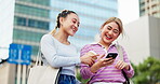 Japanese, women and laughing with phone in city for comedy blog, social media and streaming funny video. Smile, friends with mobile for communication, comic news and walking of urban commute in Japan
