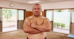 Face, confident or sumo wrestler in Japan for fitness, culture heritage or strength in stable. Japanese man, rikishi or arms crossed in gym for national sport, tradition or intimidation in tournament