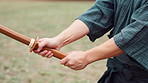 Aikido, hands and sword with person outdoor for practice, skill or technique as samurai warrior. Bamboo, training and uniform with Japanese Ninja in park for culture, heritage or tradition closeup