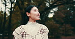 Travel, woman and thinking with smile at park for sightseeing, nature scenery and gratitude for view. Japanese person, tourist and happy outdoor in forest for holiday adventure and vacation abroad