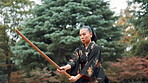 Bamboo, fight and sword with Japanese woman in forest for martial arts exercise, skill or technique. Culture, fitness and sports with serious Kendo person outdoor in nature for practice or training