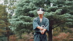 Aikido, controller and virtual reality with Japanese man in forest for metaverse exercise or training. Cyberspace, practice and VR headset with Samurai person outdoor in nature for culture or skill