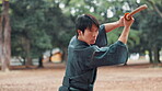 Man, Japanese and sword in park for kendo, skill development and fighting style. Asian warrior, martial arts and bamboo weapon in nature for traditional combat, technique and heritage in Hiroshima