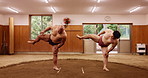 Stretching, sumo and training with Japanese people in arena for wrestling, shiko ritual and tournament. Festival, competition and game with asian men in dohyo ring of temple for culture and sports