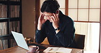 Stress, headache and man in home office with laptop, research notes or writing for freelance project. Remote work, burnout and tired Japanese writer at desk with fatigue, brain fog and online article