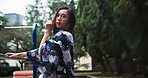 Asian woman, motion or dancing in nature for culture, rhythm or traditional performance for elegance. Jungle gym, flow or spiritual dancer moving in park for heritage, kimono art or garden in Japan