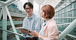 Building, city and Asian business people with tablet for meeting, discussion and planning. Creative workers, online and Japanese man and woman on digital tech for teamwork, website and research