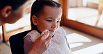 Mom, child and wiping face at breakfast with love, care or girl kid at table in Japanese home. Morning, mother and daughter together at table cleaning skin with support for growth, hygiene and family