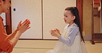 Japanese mother, child and clapping game in home for learning, coordination development and traditional culture. Family, girl or happy in living room with heritage, fun activity or dexterity with mom