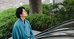 Japanese man, pride and escalator in traditional clothes, outfit and fashion as model or creative. Male person, outdoor and dress for style, culture and kimono in town for travel or adventure in city