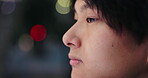 Japanese man, thinking and face for tourism, outdoor or travel at night in city, street or public. Male person, ideas and planning on vacation, sightseeing or holiday as exchange student with vision 