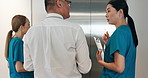 Back, doctor and walking with team in corridor or elevator for medical discussion or lift at hospital. Japanese, group and healthcare professional with nurses for appointment or meeting at clinic