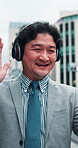 Businessman, wave or phone in city for video call, communication or travel in Tokyo. Japanese architect, headphones or tech on sidewalk with contact app, urban sightseeing or show development project
