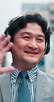 Japanese businessman, headphones and video call  in city street for tourism. travel and sightseeing. Male person, technology and outdoor as excited for buildings, architecture and development in town