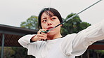 Archery, sports and Asian woman with bow in field for training, target practice and shooting competition. Drawing, anchor point and person with arrow for challenge, tournament or performance in Japan