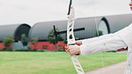 Archery, bow and sports with person training in Japan for shooting game, challenge and target practice. Competition, arrow and draw weapon with gear and athlete in field for score, aim or bullseye
