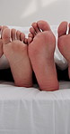 Love, relax and feet of couple in bedroom for cuddle, bonding and sleeping together. Marriage, care and relationship with closeup of people in bed at home in morning for resting, support and trust