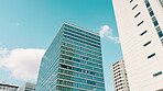 Architecture, building or infrastructure in Japanese financial district from below for business or commerce. City, corporate and sky with skyscraper office outdoor in urban town of Central Tokyo 