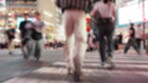 City, motion blur and people with rush for crossing road, safety perception and walking in street. Urban, legs and pedestrians in hurry for travel, commute and evening journey  for tourists in Japan
