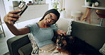 Happy woman, relax and selfie with dog on sofa for photography, weekend or bonding together at home. Female person, pet owner and animal with smile for picture, moment or capture on couch at house