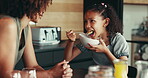 Mother, child and eating breakfast in kitchen with organic cereal, wheat nutrition and prepare meal. Woman, girl and helping with healthy food, bonding together and fibre growth of childhood at house
