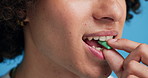Chewing gum, closeup and man in studio for fresh breath, teeth whitening and smell for odor. Hygiene, bacteria and mouth of person with bubblegum for wellness, health and cleaning on blue background