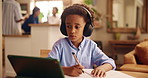 Education, laptop and writing with boy student in living room of home for development, future or growth. Computer, headphones and study with black child in apartment for distance learning or homework