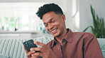 Smile, phone and man relax in home for text message, reading notification or check social media account. African person, happy and mobile in living room to download game, chat app and communication